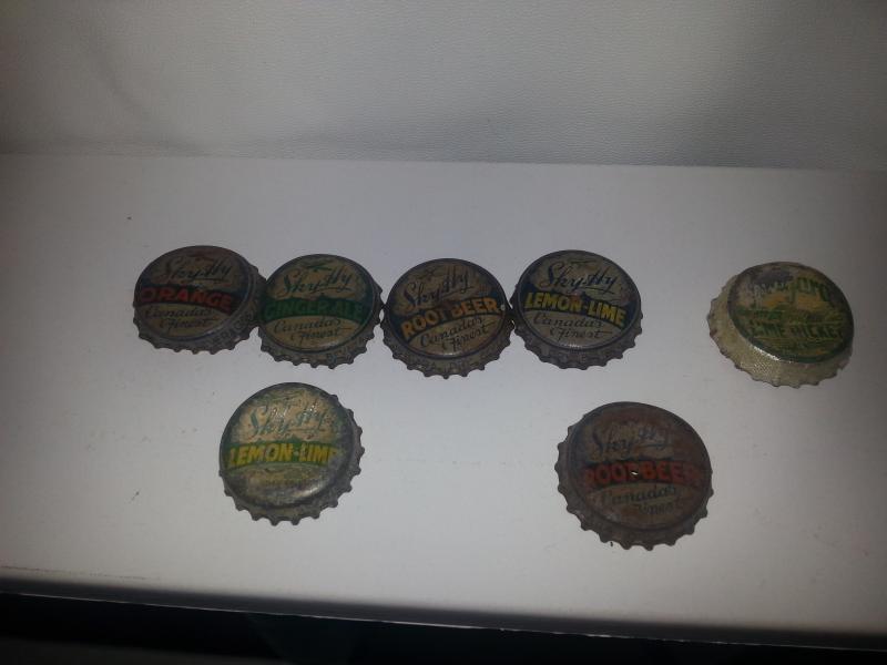 A collection of Sky-Hy bottle caps with two Lemon-Lime variants, and two Root Beer variants (different coloration of "ROOT BEER").

Also pictured is a Niagara Lemon-Lime Rickey bottle cap. Niagara LLR was also produced by Niagara Dry Beverages, but I've not seen any Niagara LLR bottles.