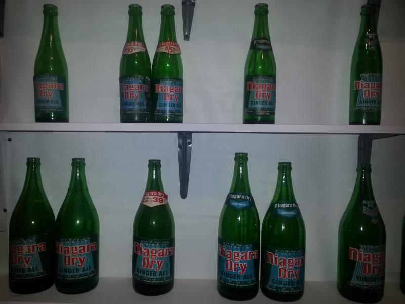 Various variations of Niagara Dry bottles with the blue falls labels. Pictured on the right are ACL (painted on) versions of the blue falls logo.